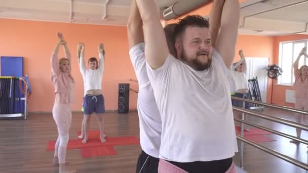 Güzel beyaz kadın eğitmen bir erkek grup oturumunda yoga teknikleri öğretir. yoga, modern fitness merkezi asanas ile kas ve sağlık güçlendirilmesi — Stok video