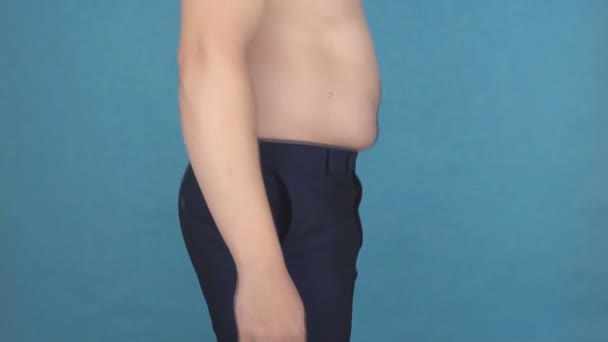 Молодой человек с обнаженным жирным животом прыгает и встряхивает жировые складки и целлюлит на животе, концепцию недоедания и ожирения, замедленной съемки, фитнеса — стоковое видео