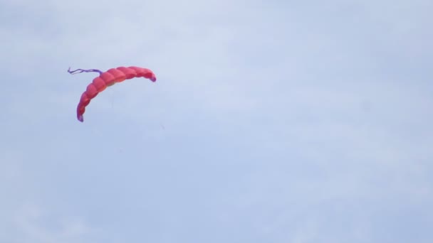 Гарний різнокольоровий змій летить на фоні блакитного неба, копіює простір, повільний рух — стокове відео