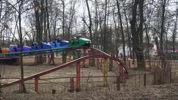 Mensen rijden een kleurrijke attractie in het pretpark in het voorjaar in Bobruisk, Wit-Rusland 03.09.19. Burgers nemen een ritje op een regenboog attractie in de open lucht. — Stockvideo