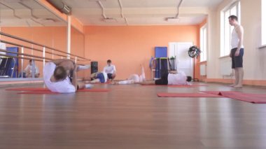 Modern bir fitness merkezinde güzel bir kafkas kız ile bireysel bir eğitmen ile Yoga dersleri, erkek arkadaşlar aşırı kilo azaltmak ve sağlık teşvik etmek için yoga yapıyor