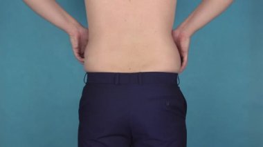 Kilolu adam dokunur ve bel yağ kıvrım sallar. Obezite, zarafetsiz vücut. Erkek sağlığı ve diyet. Şekil. Dolgun ya da yağlı kızarmış gıdalar ve içecekler bira bir sürü yiyor kalın adam.