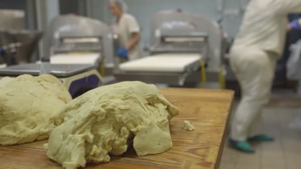 Le pasticcerie lavorano nella produzione di prodotti a base di pasta. Pezzi di pasta sono sul tavolo per fare muffin e cottura al forno — Video Stock