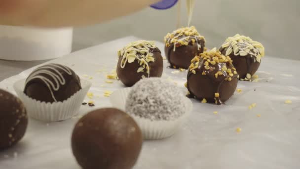 Decorar y hacer pasteles redondos de chocolate. Las mujeres hacen pasteles en una fábrica de confitería. Dulces de decoración de crema, cacao — Vídeo de stock