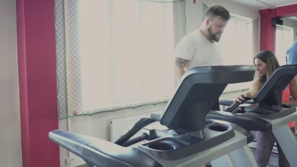 Man runs on treadmill in gym. Weight loss drills from personal coach for fat guy. Health and fitness. Exercises and Practices. Warm up before the training by thick person. Individual instructor — Stock Video
