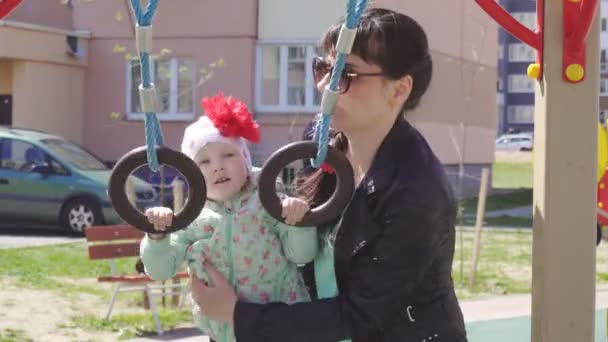 Pequena menina caucasiana bonita 3 anos brinca com sua mãe em um parque infantil moderno para crianças — Vídeo de Stock