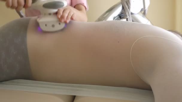 A specialist girl in a beauty salon makes a modern procedure for a fat man to reduce excess weight, restore skin density and elasticity. Apparatus massage LPG, relief — Stock Video