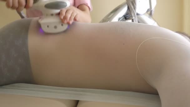 Een gespecialiseerd meisje in een schoonheidssalon maakt een moderne procedure voor een dikke man om overtollig gewicht te verminderen, de huid dichtheid en elasticiteit te herstellen. Apparaat massage LPG, reliëf — Stockvideo