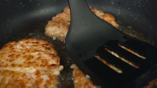 Closeup a person fries patties or cutlets for hamburgers in a pan in boiling oil. Unhealthy Lifestyle, fried and high caloric food. The risk of obesity and overweight. in Slow motion. — Stock Video