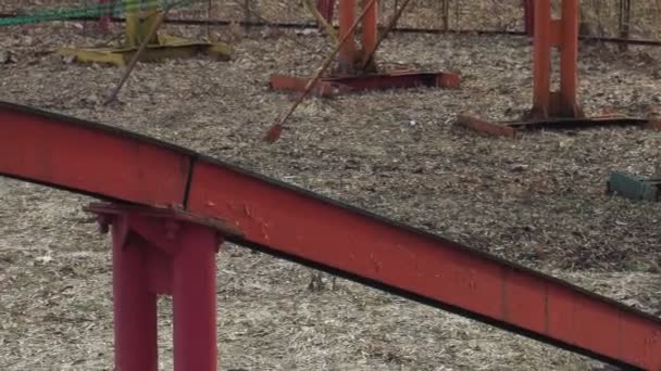 Fermer Acolor attraction manèges sur les rails dans le parc d'attractions au printemps. Une attraction colorée roule sur les pistes dans le parc d'attractions en plein air . — Video