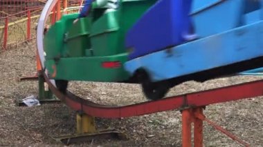 çekim renkli bir cazibe bahar eğlence parkında raylar insanlar sürmek. Bir gökkuşağı cazibe açık havada bir binmek alınır.