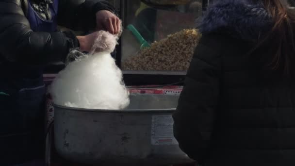 Een persoon draait witte suikerspin met een geautomatiseerde machine op een kermis. Een verkoper maakt witte snoep floss met een moderne machine in het pretpark. — Stockvideo