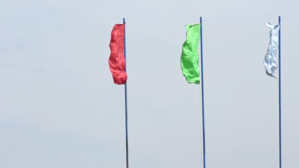 Flerfärgade festliga flaggor utvecklas i vinden mot en blå himmel, bakgrund, festliga, slow motion, kopiera utrymme — Stockvideo
