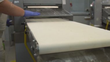 Bir kadın şekerci pasta ve çörekler yapmak için bir kılıf üzerinde hamur dışarı rulo. Fırın Imalatı, gıda endüstrisi