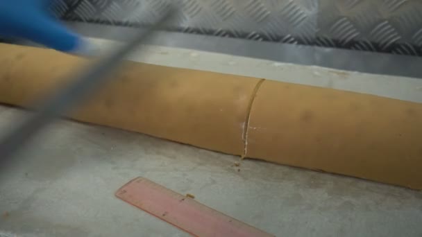 Confectioner cuts a biscuit roll with cream. Cake bakery product. Manual manufacture of sweet dessert with caramel or buttercream. Flour confectionery production. — Stock Video