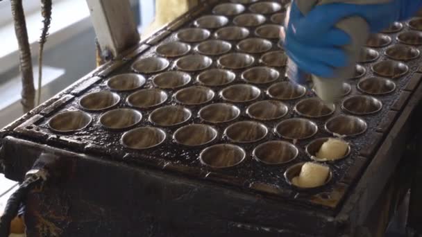 Fabrication manuelle de pâtisseries ou biscuits à la farine sous forme de noix. Dessert avec lait condensé. La pâte est versée dans une poêle ou un plateau à poche. Préparation d'un gâteau pour la cuisson au four . — Video