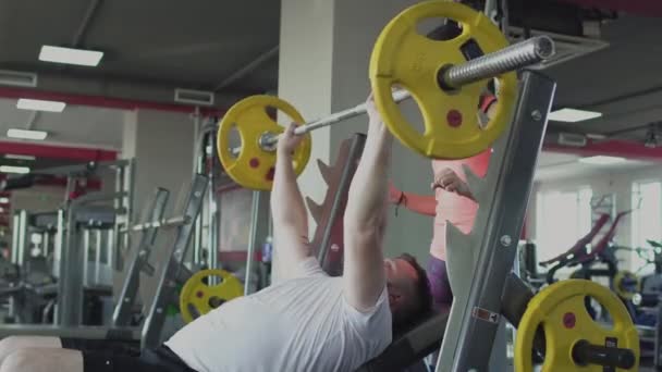 Individual training with girl coach for man in gym. Thick obese guy with private instructor doing physical jerks and exercises in fitness center. Overweight person and woman burn calories by workout. — Stock Video