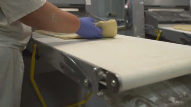 Bir kadın şekerci pasta ve çörekler yapmak için bir kılıf üzerinde hamur dışarı rulo. Fırın Imalatı, gıda endüstrisi