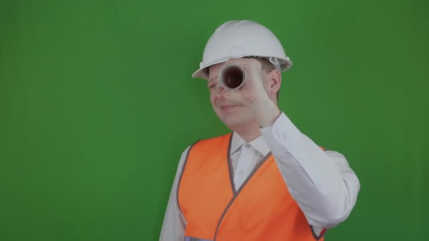 Funny engineer fool around with technical drawing. Amusing Builder looks through the paper like a telescope. Chromakey. Real estate market. Boss or chief in white helmet and orange reflective vest. — Stock Video