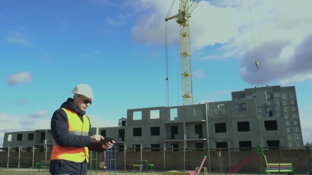 Construção de edifícios residenciais. Engenheiro trabalhando no computador tablet eletrônico. Mercado imobiliário. Builder insere dados no gadget. Chefe ou chefe olha 3D desenho técnico . — Vídeo de Stock