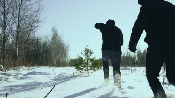 Hombres felices están bailando cerca del árbol de Navidad en el invierno en el bosque antes de año nuevo en la ciudad. Concepto de inicio de la celebración. Movimiento lento — Vídeo de stock