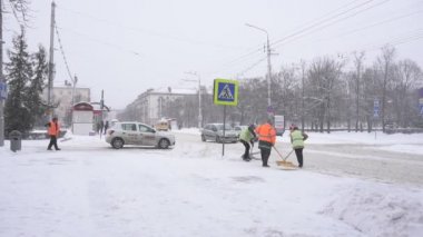 Bobruisk, Beyaz Rusya - 14 Ocak 2019: Sinyal yelekli kapıcıkışın kentte ki karları temizler, yavaş çekim