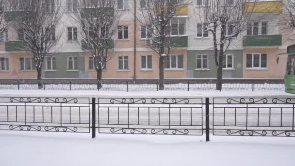 Der Bus fährt vor dem Hintergrund eines alten Gebäudes in der Stadt. Schneefall, Winter, Zeitlupe — Stockvideo