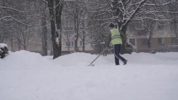 Homme concierge tuera la neige dans la ville, tempête de neige BOBRUISK, BELARUS - 14 JANVIER 2019 — Video