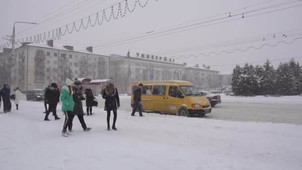 BOBRUISK, BELARUS - 14 DE ENERO DE 2019: La gente en la ciudad está esperando en la parada de autobús para el transporte, está nevando en la calle, el invierno, a cámara lenta — Vídeos de Stock