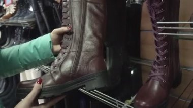 Kız alışveriş için mağazadan kışlık ayakkabı seçiyor.