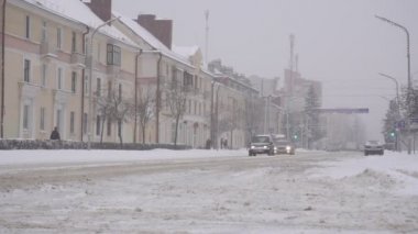 Arabalar ve nakliye araçları şehirdeki karlı bir yolda ağır çekimde Bobruisk, Belarus - 14 Ocak 2019