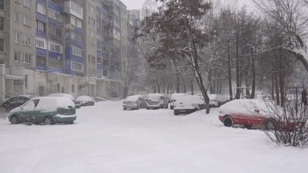 Auto parcheggiate in un tranquillo cortile residenziale, nevica, inverno. Sfondo, spazio di copia, rallentatore — Video Stock