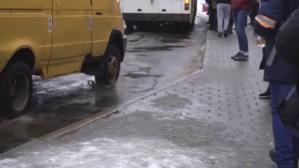 사람들은 버스 정류장에서 대중교통을 기다리고 있습니다. 겨울 도시, 눈이 내리는 느리고 느린 동작의 도시, 벨라루스 - 2019 년 1 월 14 일 — 비디오