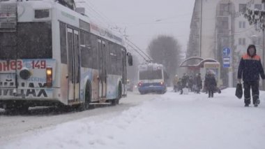 Bobruisk, Belarus - 14 Ocak 2019: İnsanlar şehirde kışın otobüs durağına gelir, kar yağışı, ağır çekim