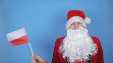 Mavi arka planda Polonya bayrağı sallayan sakallı Noel Baba kostümlü bir adam. Dünyada yeni yıl tatili kavramı