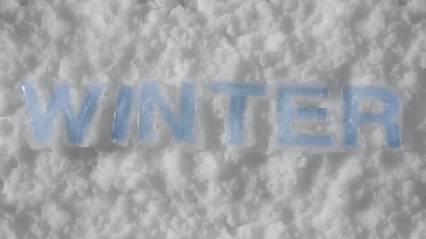 Letters made of ice melt in snow, timelapse. Background. Concept end of winter and beginning of spring. Christmas and New years eve. Cold weather gives way to warm weather. Holidays and celebrations — Stockvideo