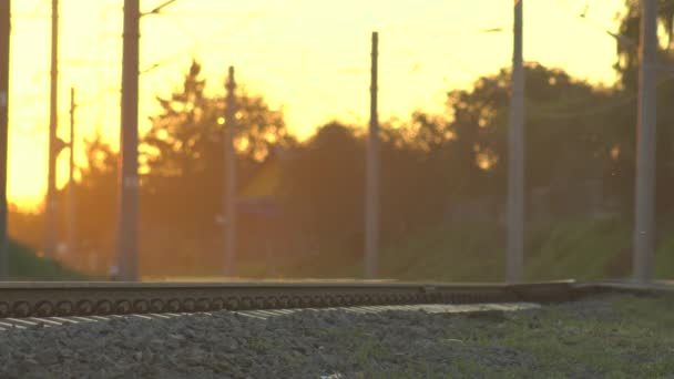 Coches, personas, vehículos y peatones se mueven a través del paso del nivel del ferrocarril en la puesta del sol. Peligroso tramo de ferrocarril electrificado para accidente de tren, catástrofe o accidente. Fin de la jornada laboral . — Vídeos de Stock