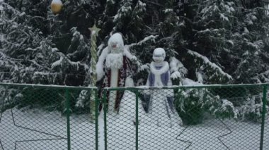 Noel Baba 'nın Oyuncakları ya da Ded Moroz ve Snegurochka, öğleden sonra kar fırtınasında şehrin merkez meydanındaki Noel ağacının yanında kar yağışı altındalar. Yeni yıl arifesi yavaş kar fırtınasında şehirde.