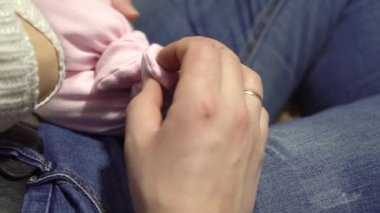 Baba küçük bir kızı bacağından tutuyor, yakın plan, babalık, yakın plan.