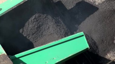 Asfalt zıpzıp dolu özel yol ekipmanları yola yeni bir asfalt karışımı seriyor, yakın plan.