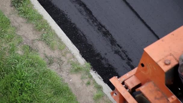 Vägvält rullar nyligen lagt asfalt på vägen, bakgrund, närbild, industri — Stockvideo