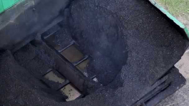 En asfaltläggare lägger ny asfalt ovanpå en gammal vägreparation. Särskild vägutrustning, industri, närbild — Stockvideo