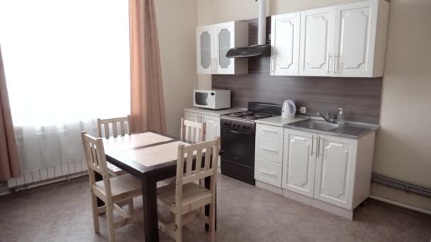 Nowoczesne wnętrze w kuchni, kuchenka gazowa, stół z krzesłami na tle okna, dom — Wideo stockowe
