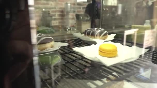 Les bonbons sont vendus dans le magasin sur une vitrine croissants, gâteaux et muffins, fond — Video