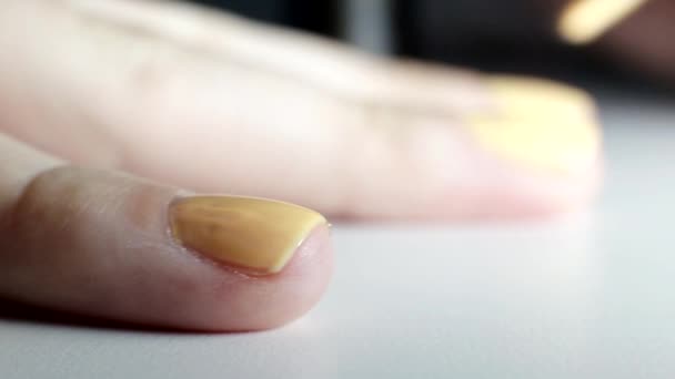 Chica hace una manicura en las uñas, aplica esmalte de uñas naranja, salón de belleza, macro — Vídeos de Stock