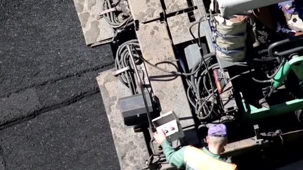 Les paveurs d'équipement spécial et les travailleurs posent un nouveau mélange d'asphalte sur la route. Industrie de la réparation routière — Video