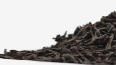 Macro shot, saf büyük Seylan yaprağı siyah çayı beyaz arka planda yatar. Boşluğu kopyala, metin için yer aç. Kamera yana kayar