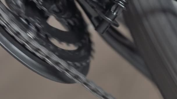 Zbliżenie pierścieni łańcuchowych na rowerze górskim MTB. Praca łańcuchowego układu napędowego. Przekładnia, zmiana prędkości. Zmiana biegów na korbie rowerowej. Przód wykolejenia. Makro strzał z niskiego kąta. Koło obraca się i obraca — Wideo stockowe