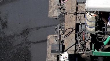 Özel ekipman kaldırımları ve işçiler yola yeni asfalt karışımları seriyorlar. Yol onarım endüstrisi