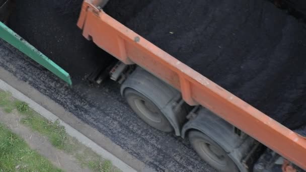 Le camion à benne verse de l'asphalte chaud dans le pavé, les travaux routiers, l'industrie . — Video